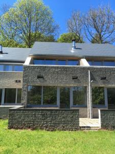 a brick house with a gray roof at le dépot 2 appartement 406 in Malmedy