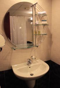 lavabo blanco en el baño con espejo en Cosmopolitan Hotel, en Beirut