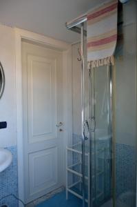 La salle de bains est pourvue d'une douche avec une porte en verre. dans l'établissement LA CASA DELLA MUSICA, à Castellammare di Stabia