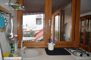 une cuisine avec évier et cuisinière ainsi qu'une fenêtre dans l'établissement LA CASA DELLA MUSICA, à Castellammare di Stabia