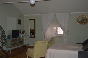 - une chambre avec un lit, une télévision et une fenêtre dans l'établissement LA CASA DELLA MUSICA, à Castellammare di Stabia
