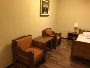 een kamer met 2 stoelen en een tafel en een bed bij Pensiunea Igazland *** in Dumbrava