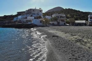 a beach with white buildings and the ocean at Theaktis Homes in Kaloi Limenes