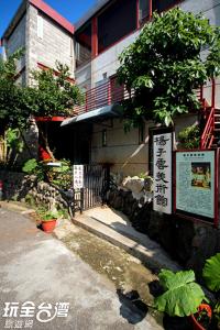 三芝乡美术行馆民宿的一棵树旁的建筑物前的标志