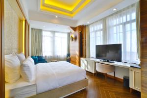 um quarto de hotel com uma cama, uma secretária e uma televisão em Mercure Istanbul Sirkeci em Istambul