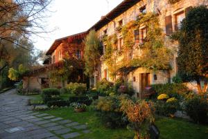 a building with a garden in front of it at Hotel L'Ultimo Mulino in Bannia