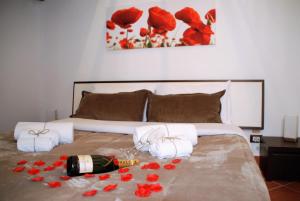 a bed with a bottle of wine and red flowers on it at Casa vacanze Ai Corrieri in Palermo