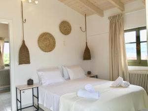a bedroom with two beds with white sheets and towels at Alkestis Studios in Lixouri
