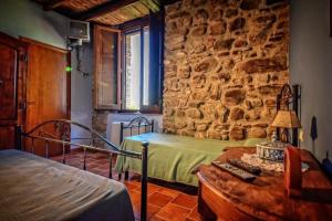 a bedroom with two beds and a stone wall at Tenuta TerraRossa in Rossano