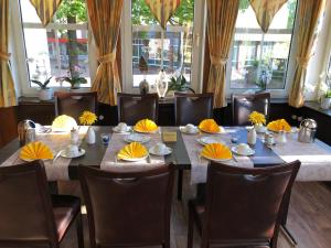 una sala da pranzo con tavolo, sedie e finestre di Hotel Stadt Munster a Munster im Heidekreis