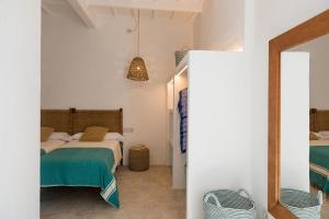 - une chambre avec un lit et un miroir dans l'établissement roques, à Ciutadella