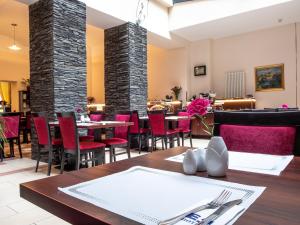 プラハにあるEA エンバシー プラーグ ホテルのダイニングルーム(テーブル、赤い椅子付)