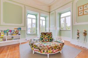 a living room with a chair and windows at Vila Recife Hotel in Albufeira