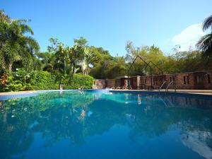 een groot zwembad met blauw water en bomen bij Samui Garden Home - SHA Extra Plus in Lamai