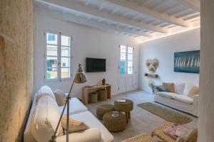 a living room with white furniture and a tv at roques in Ciutadella