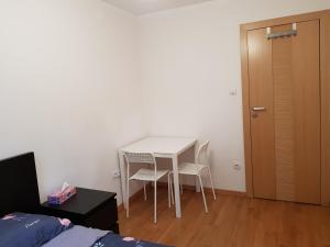 een witte tafel en stoelen in een kamer met een deur bij MirrorRoom PL CityCenter in Warschau