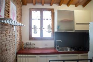 cocina con fregadero y ventana en Pepe Nero by HelloElba, en Portoferraio