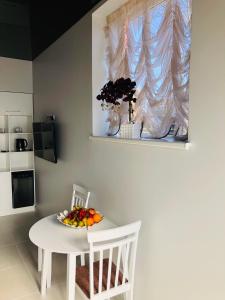 a white table with a bowl of fruit on it at Romeo VIP apartamentai in Panevėžys
