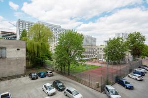 parking z samochodami zaparkowanymi przed budynkami w obiekcie Apartments Warsaw Pereca by Noclegi Renters w Warszawie +12 zdjęć