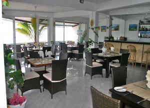 ein Esszimmer mit Tischen und Stühlen sowie ein Restaurant in der Unterkunft Le Recif Hotel Rodrigues in Rodrigues Island