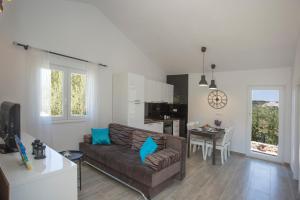 a living room with a couch and a kitchen at SIESTA, a house in the nature on the island in Drvenik Veli