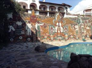 a mural on a wall next to a swimming pool at Posada de la Mision, Hotel Museo y Jardin in Taxco de Alarcón