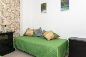 a bedroom with a bed with green sheets and pillows at Nueva Vista 2º-4 in Cullera +20 photos