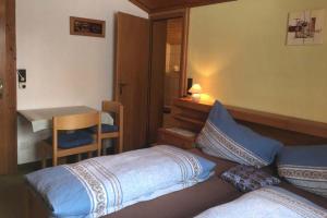 Schlafzimmer mit einem Bett, einem Schreibtisch und einem Tisch in der Unterkunft Ferienwohnung Schwalbenwandblick in Saalfelden am Steinernen Meer