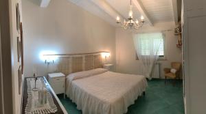 a bedroom with a bed and a chandelier at Residence Baia Infreschi in Marina di Camerota