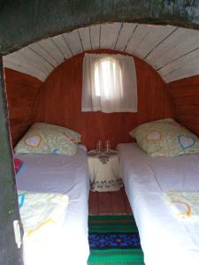 two beds in a small room with a table at Angelinin Konak in Negotin