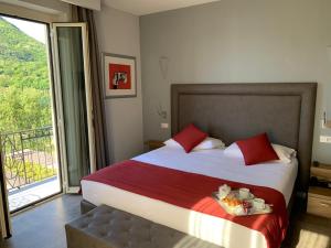 a bedroom with a bed with a tray of food on it at Hotel Ristorante La Quartina in Mergozzo