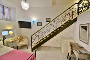 a bedroom with a staircase with a bed and a desk at 2-level Apartment "Mandraki" in Hydra