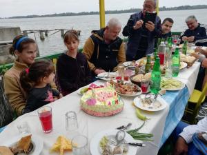 a group of people sitting around a table with a birthday cake at Angelinin Konak in Negotin +32 photos