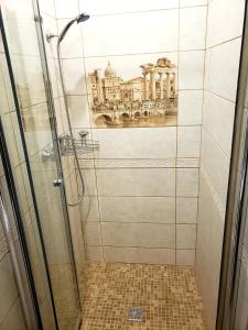 een badkamer met een douche en een foto van het Louvre bij Little Paris Apartment in Tsjernivsi