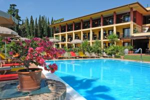 un hotel con una gran piscina con una maceta en Villa Madrina Lovely and Dynamic Hotel, en Garda