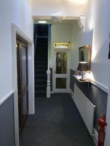 a hallway with a staircase leading to a institution at Harleys Reads Avenue in Blackpool