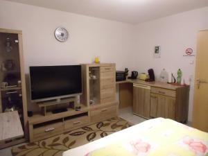 a room with a television on a wooden entertainment center at Ferienwohnung Keil in Lahr +9 photos