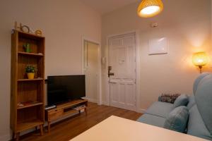 een woonkamer met een bank en een televisie bij For You Rentals Chueca Apartment BRC42 in Madrid