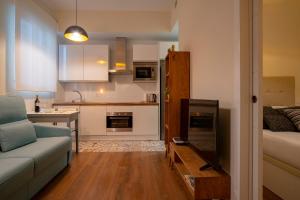 een woonkamer met een bank en een keuken bij For You Rentals Chueca Apartment BRC42 in Madrid