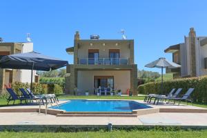 a villa with a swimming pool in front of a house at Saint Paul's Residences in Sani Beach