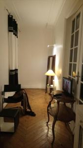 uma sala de estar com uma mesa e um candeeiro em Toureifelchampselysee em Paris