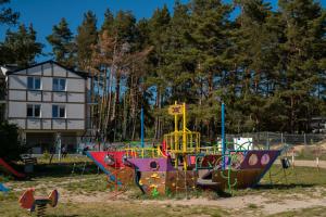 plac zabaw ze sprzętem do zabawy w parku w obiekcie APARTAMENT 19B BLUE MARINE Poddąbie Basen Odkryty Brodziki Plac Zabaw w Poddąbiu