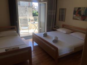 a bedroom with two beds and a balcony with a view at jakov in Podgora