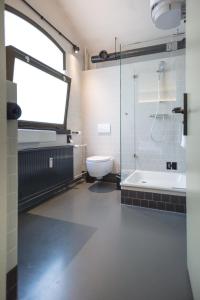 a bathroom with a shower and a toilet and a sink at Alibi Hostel Leeuwarden in Leeuwarden