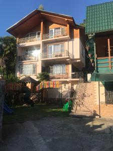ein großes Haus mit einem Balkon an der Seite in der Unterkunft Guest House Peschaniy Bereg in Sochumi