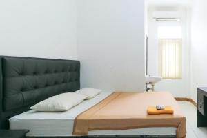 a bedroom with a large bed with a black headboard at Riviera Residence in Balikpapan