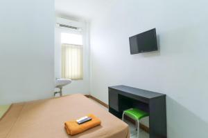 a bedroom with a bed with a desk and a television at Riviera Residence in Balikpapan
