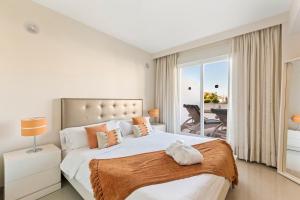 a bedroom with a large bed and a balcony at Cortijo Del Mar Resort in Estepona