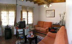 a living room with a couch and a tv at Casa Paulino in Los Corrales de Buelna