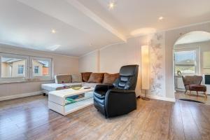 a living room with a couch and a chair at Ferienwohnungen zum Ostseestrand in Ahlbeck